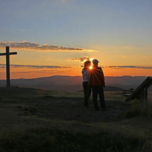 Ein Paar beobachtet den Sonnenaufgang am Belchen.