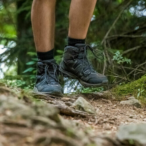 Es sind Wanderschuhe eines Wanderers zu sehen.